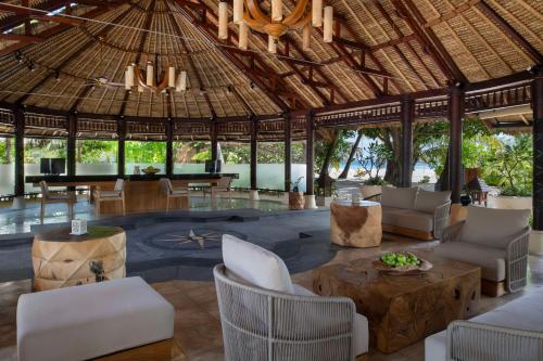 a pavilion with chairs and a table in a resort at Banyan Tree Vabbinfaru in Male City