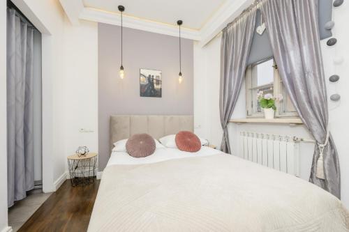 1 dormitorio con 1 cama blanca grande y 2 almohadas en Atmospheric Apartment in Mariensztat Warsaw by Renters en Varsovia
