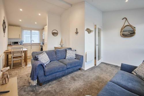 a living room with a blue couch and a kitchen at Host & Stay - Sea View Road in Bessingby