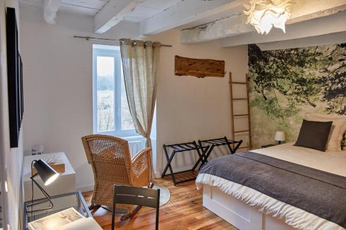 une chambre avec un lit et une grande fenêtre dans l'établissement La Breizhidence, à Combourg