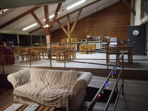 a couch in a room with tables and chairs at Auberge de Jeunesse HI Pontivy in Pontivy