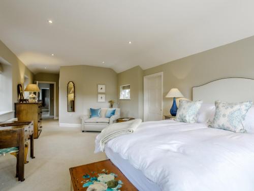 um quarto com uma grande cama branca e uma sala de estar em 5 Bed in Sherborne 79062 em Wincanton