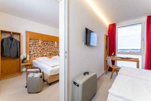 een hotelkamer met een slaapkamer met een bed en een raam bij PLAZA INN Dachau - München in Dachau
