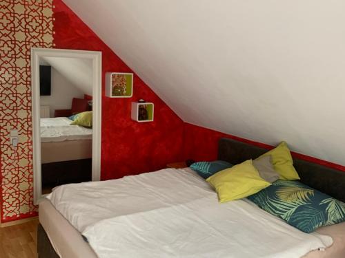 uma cama num quarto com uma parede vermelha em Schmuckes Einfamilienwohnhaus em Spielberg