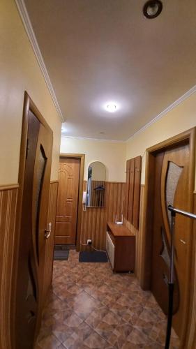 a bathroom with a toilet and a sink and wooden doors at Комфортная 1-комнатная Новопречистенская 1 in Cherkasy