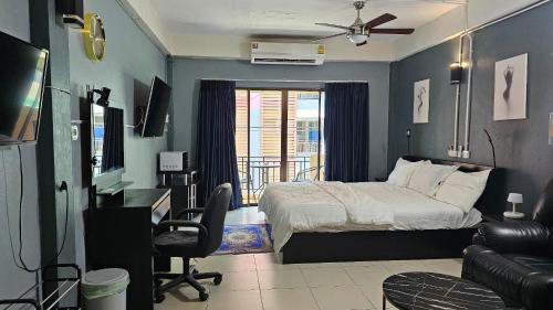 a bedroom with a bed and a desk and a chair at Nieuw Vlaanderen in Pattaya