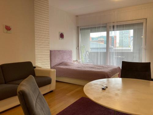 a bedroom with a bed and a table and a window at Apartment Green Gold in Zagreb