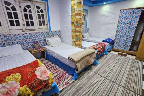 a room with two beds in a room with patterns at Comfy Hostel-Style Home Near Pyramids in Cairo
