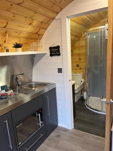 a kitchen with a sink and a shower and a tub at Bonnie Brae Pod in Fort William