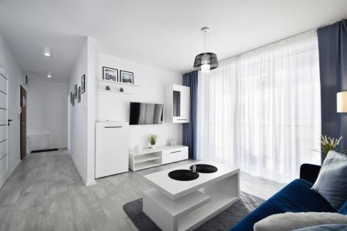 a living room with a couch and a coffee table at RentPlanet - Apartament Biały Dom in Kołobrzeg