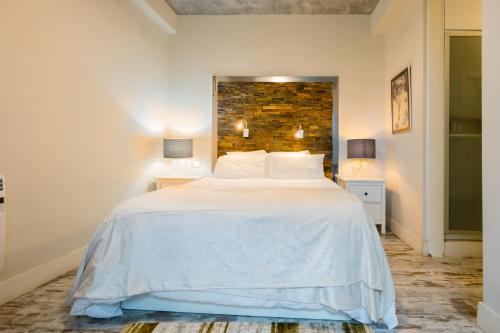 a bedroom with a large white bed and two lamps at Duplex diseño arabe in Las Pajanosas