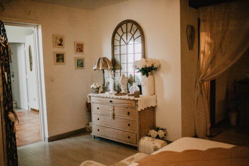 a bedroom with a dresser and a mirror at Chez Géraldine in Montels