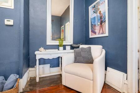 a living room with a white chair and a blue wall at Downstairs 2 Bedroom Apt- Pet Friendly- walking distance to beach & shops in Michigan City