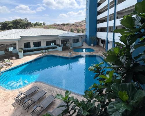 a large swimming pool next to a building at Mutiara Melaka Beach Resort by ISRA in Tangga Batu
