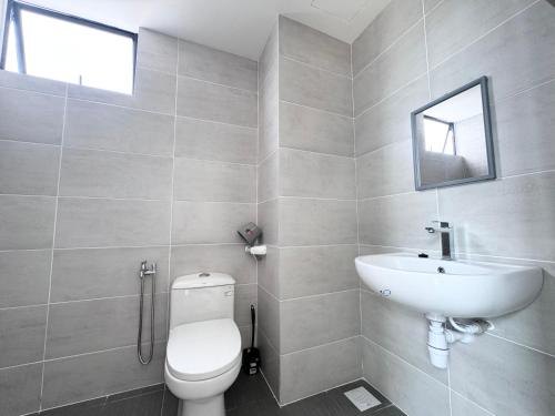 a bathroom with a white toilet and a sink at Mutiara Melaka Beach Resort by ISRA in Tangga Batu