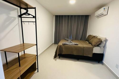1 dormitorio con cama y estante en BlueCoast 205 Apartment, en Rio das Ostras