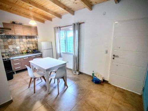een keuken met een witte tafel en stoelen in een kamer bij Cedro Azul in La Cumbre