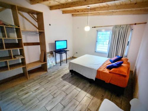 1 dormitorio con 1 cama y TV de pantalla plana en Cedro Azul en La Cumbre