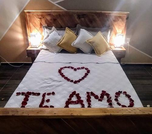 een bed met een hart gemaakt van rode rozen bij PENEDO ACONCHEGO LOFT: VISTA, CONFORTO E NATUREZA! in Penedo