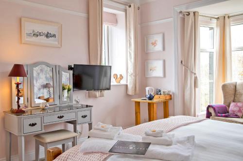 a bedroom with a bed and a dresser and a television at Sheriff Lodge in Matlock