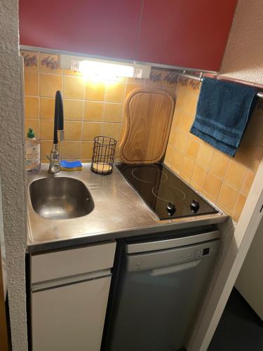 une petite cuisine avec un évier et une cuisinière dans l'établissement Studio tout confort pied des pistes avec balcon et wifi, à Villarembert