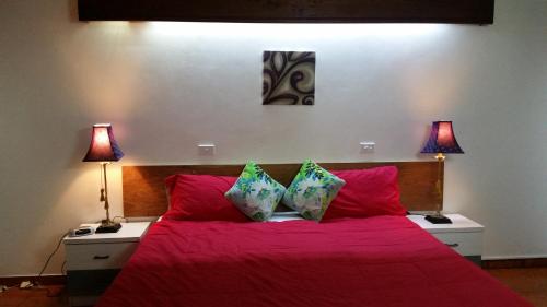 a bedroom with a red bed with two lamps at Harbour Views in Port Vila