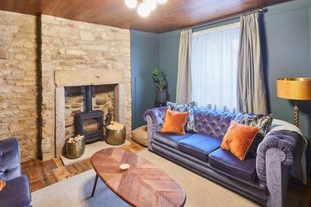 a living room with a couch and a fireplace at Host & Stay - Hecklers Cottage, Barnard Castle in Barnard Castle