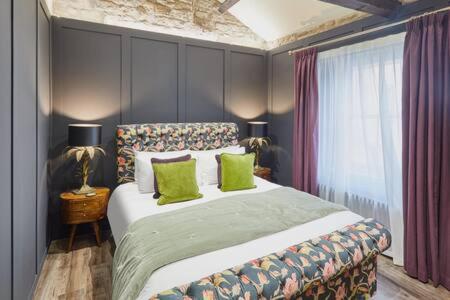 a bedroom with a large bed with green pillows at Host & Stay - Hecklers Cottage, Barnard Castle in Barnard Castle