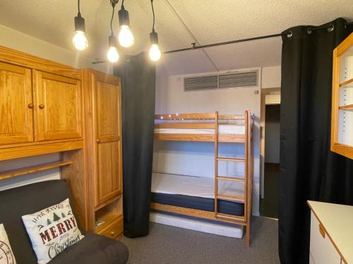 - une chambre avec des lits superposés et une chambre avec un canapé dans l'établissement Studio tout confort pied des pistes avec balcon et wifi, à Villarembert