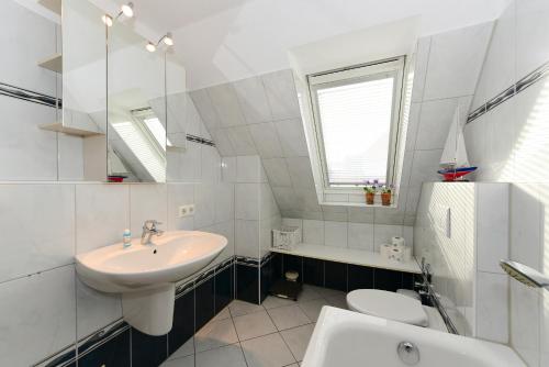 ヴィーク・アウフ・フェールにあるHaus Martens Whg 04の白いバスルーム(洗面台、トイレ付)