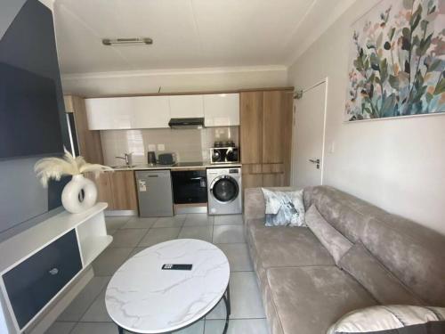 a living room with a couch and a table at One Bedroom The Blyde in Pretoria