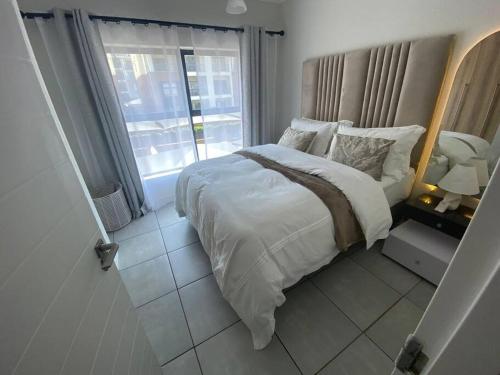 a bedroom with a large bed and a window at One Bedroom The Blyde in Pretoria
