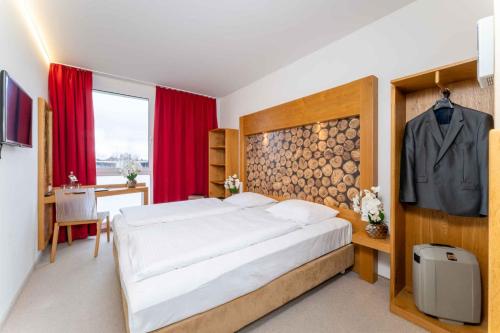 a bedroom with a large white bed and a desk at PLAZA INN Dachau - München in Dachau
