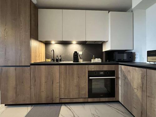 une cuisine avec des armoires blanches et un four à plaques de cuisson dans l'établissement Le Niou, Appartement avec Parking GRATUIT, à Marseille