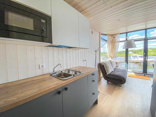 a kitchen with a sink and a counter with a chair at Twin Boat in Ekerö