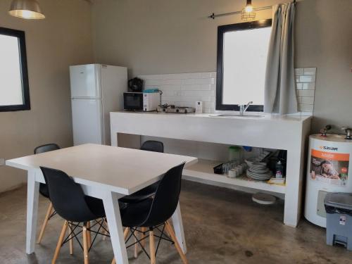 a kitchen with a sink and a table and chairs at Cabañas Norden San Pedro in San Pedro