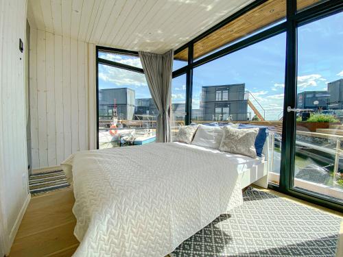 a bedroom with a white bed and a large window at Twin Boat in Ekerö