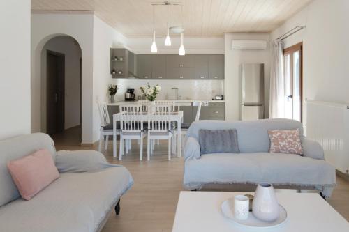 sala de estar con 2 sofás y cocina en House Belelis, en Afionas