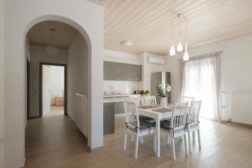 a kitchen and dining room with a white table and chairs at House Belelis in Afionas