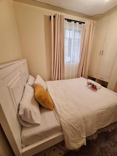 ein Schlafzimmer mit einem weißen Bett mit Blumen darauf in der Unterkunft The Sunset in Nairobi