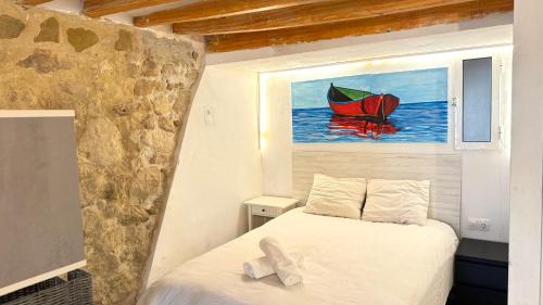 een slaapkamer met een bed en een schilderij van een boot bij Loft de piedra en centro histórico - Casco Antiguo in Alicante