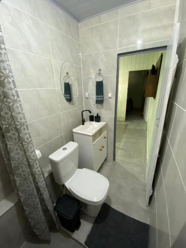 a bathroom with a toilet and a sink and a mirror at Casa em Balneário Camboriú in Balneário Camboriú
