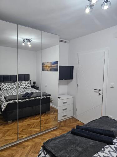 a bedroom with two beds and a mirrored wall at Apartman Laura in Karlovac