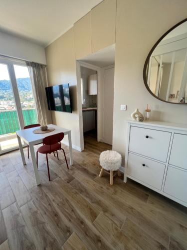 - un salon avec une table et un miroir dans l'établissement Appartement ensoleillé à Ajaccio, à Ajaccio