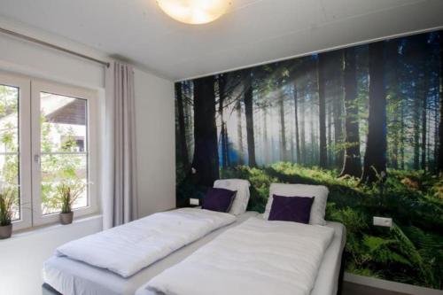 a bedroom with two beds and a painting of trees at Familiehuis De Erica - 12 p in Otterlo