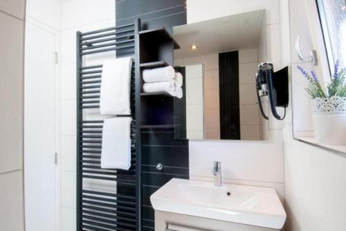 a bathroom with a sink and a mirror at Familiehuis De Erica - 12 p in Otterlo