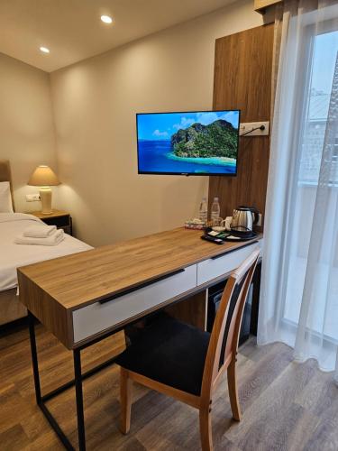 a room with a desk with a television on a wall at Hotel Avenue 30 in Yerevan