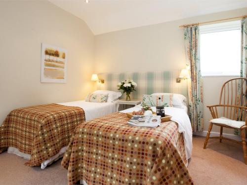 1 dormitorio con 2 camas, mesa y ventana en 2 Bed in Howden G0104, en Saltmarshe