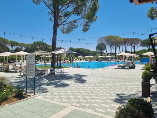 une piscine avec des parasols et des personnes dans un complexe dans l'établissement Blue Sting Apartment - 147, à Durrës