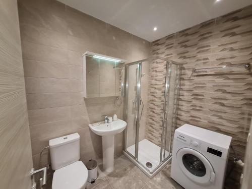 uma casa de banho com um lavatório e um chuveiro. em Tarxien - Lovely 3 bedroom unit em Tarxien